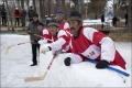 Players watch from the side. Note that the "boards" are actually tightly-packed snow.