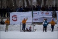 Goaltender makes a save, with spectators looking on.